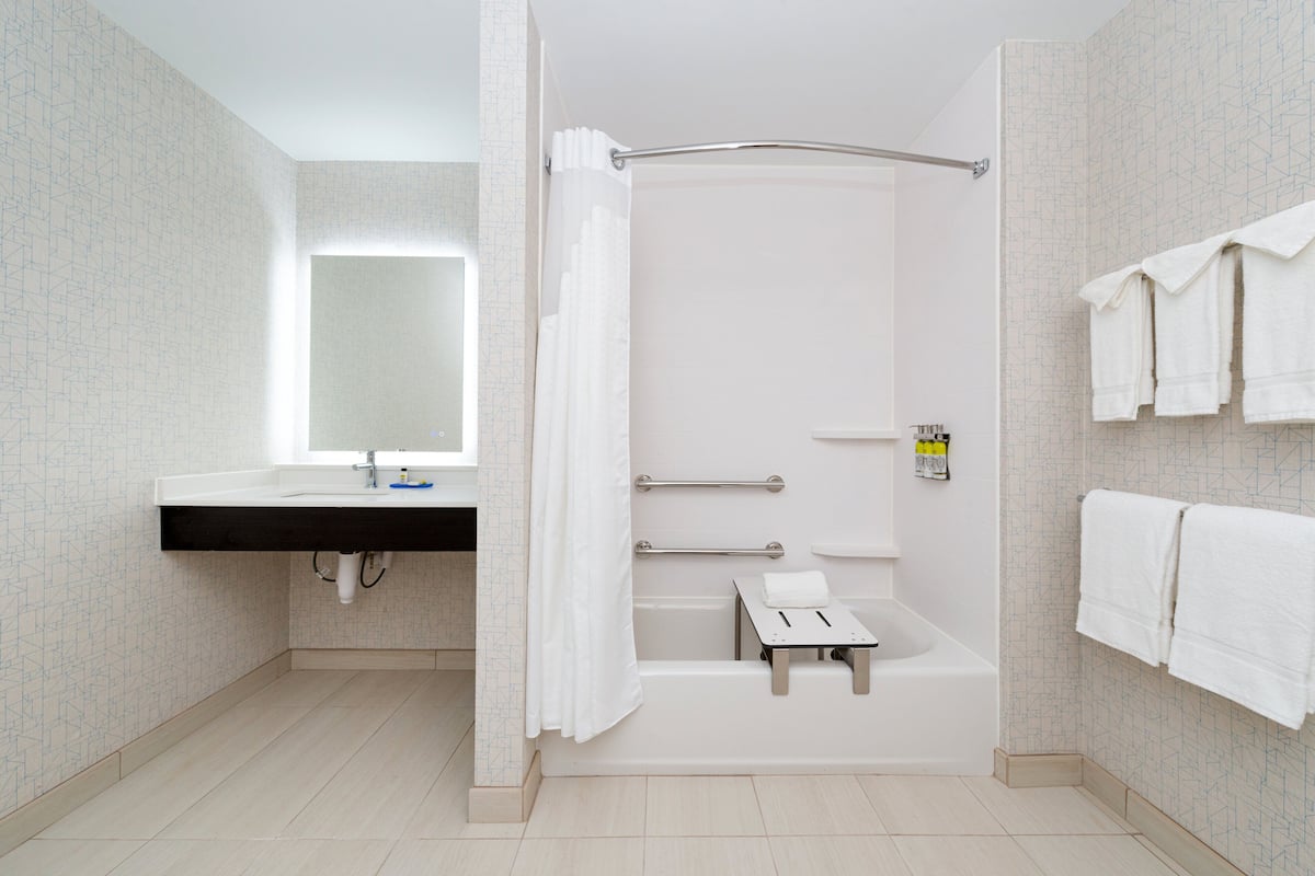 A modern bathroom with a shower, a sink, and a mirror.