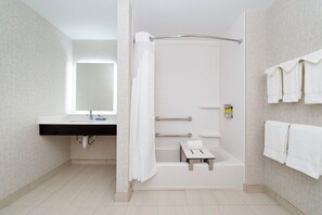 Een moderne badkamer met een douche, wastafel en spiegel.