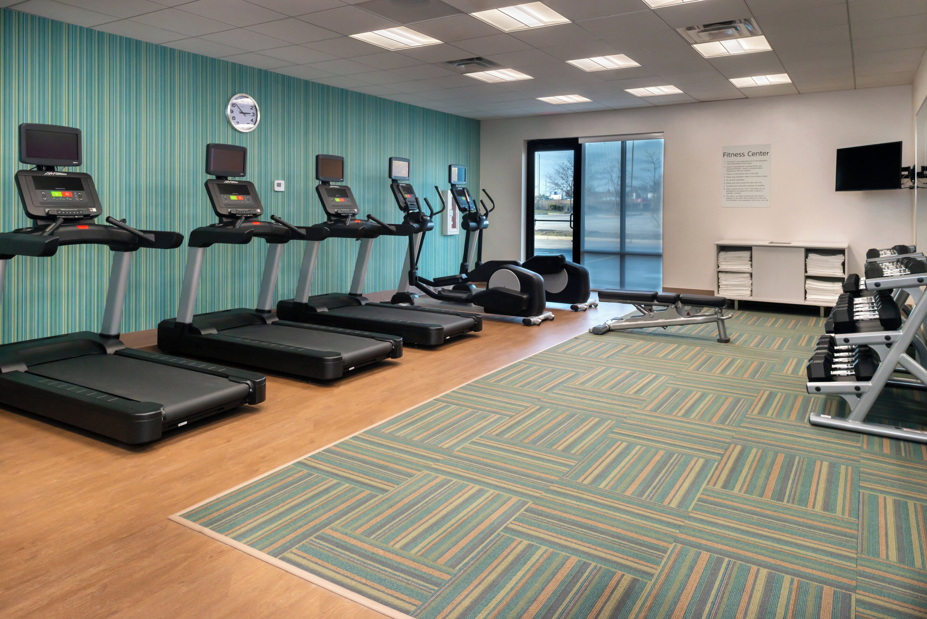 A fitness center with treadmills, elliptical machines, and weight equipment.