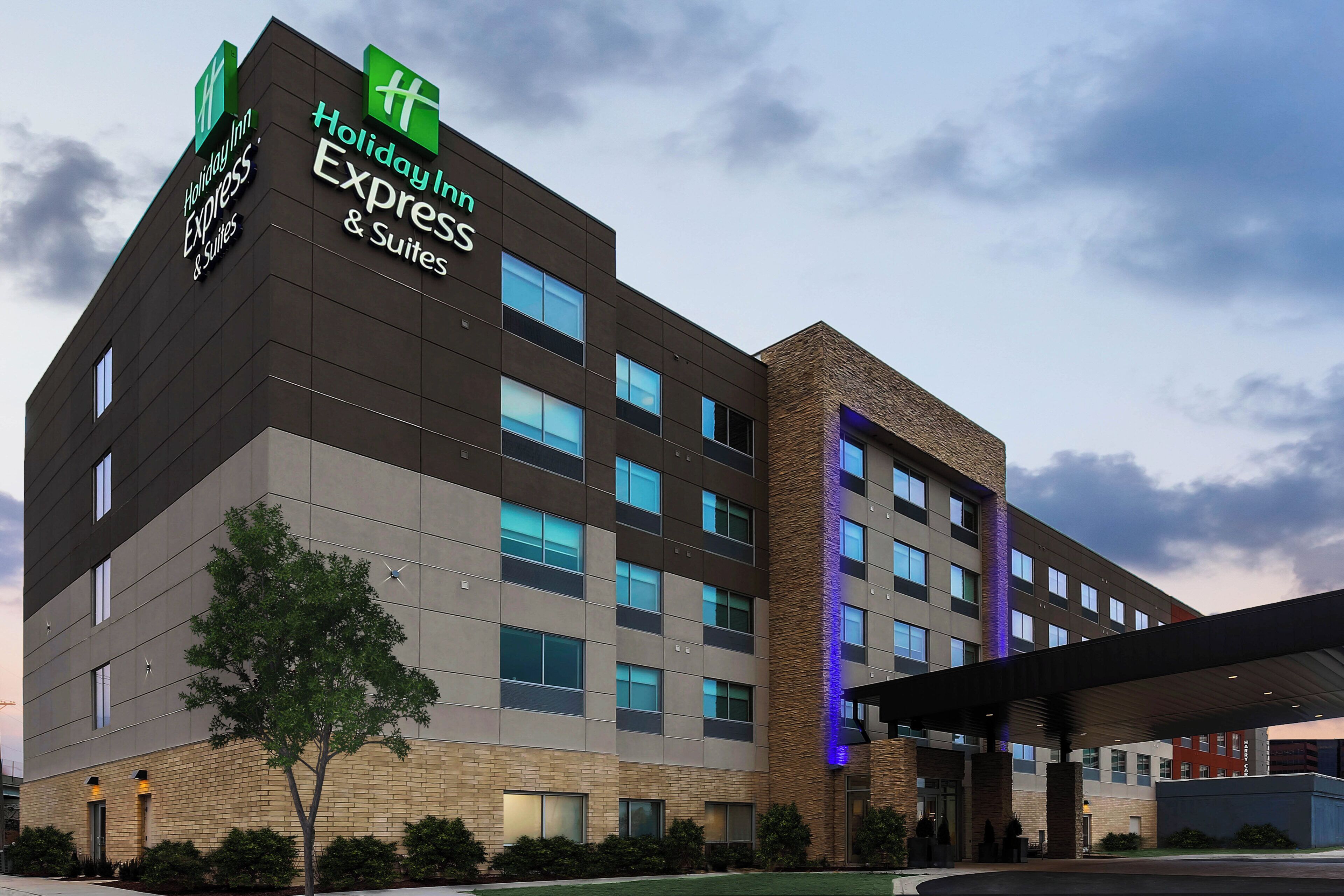 Un hotel Holiday Inn Express & Suites con un diseño moderno, que presenta fachada de ladrillo y múltiples ventanales.