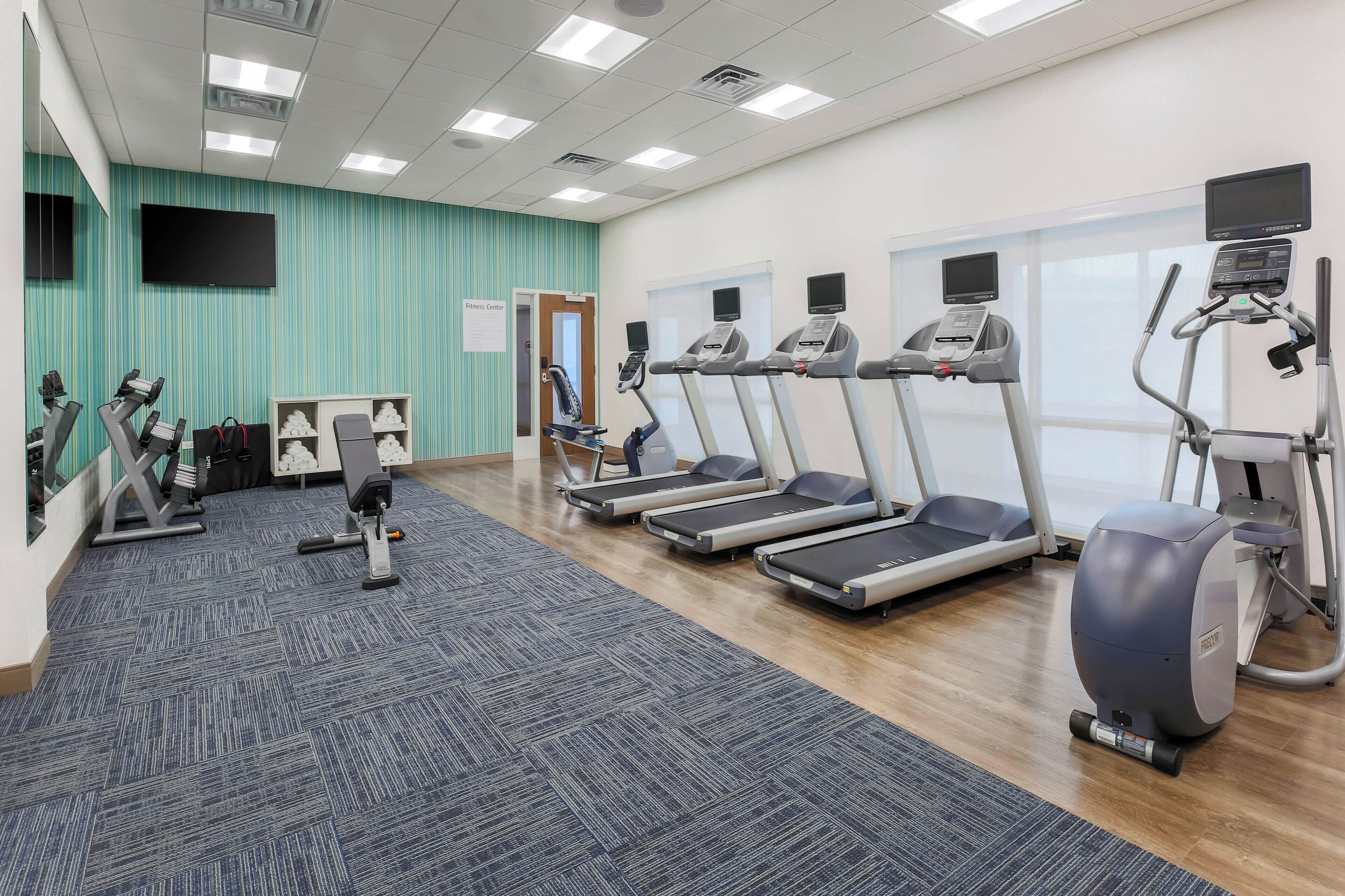 A fitness center with treadmills, elliptical machines, and weight machines.