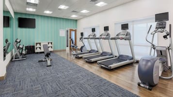 A fitness center with treadmills, elliptical machines, and weight machines.