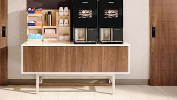 A modern coffee station with two coffee machines, a coffee grinder, and various coffee pods and cups.