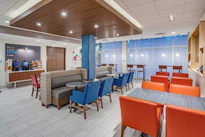 A modern cafe with seating arrangements, a coffee station, and large windows providing natural light. - Holiday Inn Express & Suites Elkhart North by IHG (Elkhart)
