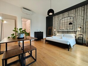 A modern bedroom with a bed, bedside table, and a potted plant. - B&B La Marmora 39 (Florence)