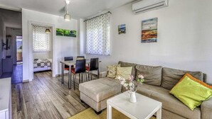 Un salon moderne avec un canapé, une table basse et un coin repas.