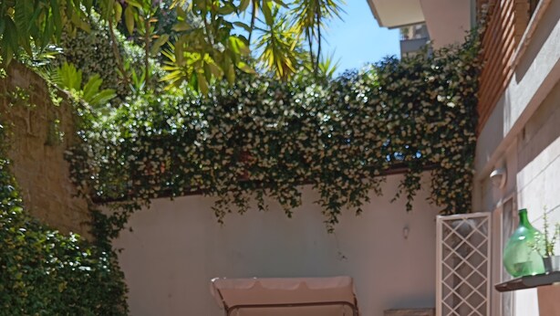 Une terrasse extérieure avec un sol en briques, une table couverte et des chaises.