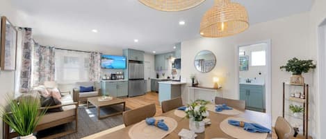 En moderne lejlighed med spiseplads, køkken, opholdsstue og balkon.