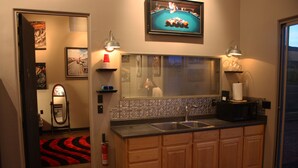 A modern kitchen with wooden cabinets, a built-in sink, and a window with blinds. - The motorsport studio (Cave Creek)