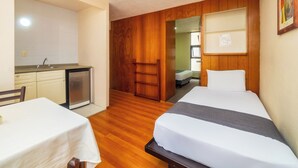 A compact hotel room with a kitchenette, a bed, a small table, and a wooden floor. - Capital O Hotel Suites Marne, Mexico City (Mexico City)