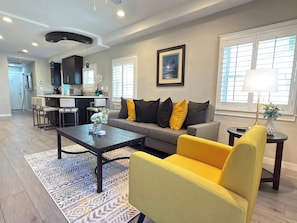 Relax in this stylish living room with a sofa, armchair, and coffee table, perfect for unwinding with a view.