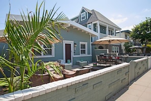 Enjoy a relaxing stay in this charming two-story home with a spacious front porch and lush greenery.