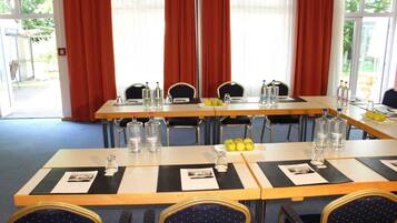 A conference room with tables set for meetings, equipped with water bottles, glasses, and nameplates.