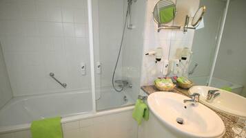 Een moderne badkamer met een douche met glazen wand, twee wastafels en een grote spiegel.