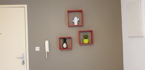 A cozy retreat features a unique collection of framed artwork, a telephone, and a door with a handle.