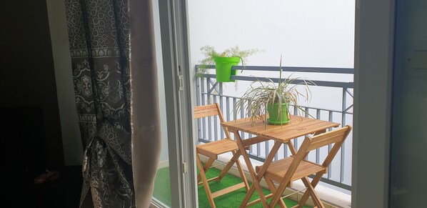 Enjoy a peaceful moment on this balcony with a table and chairs, perfect for taking in the views.