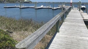 Eine hölzerne Pier, die sich in ruhiges Wasser erstreckt, mit Anlegestellen und Booten.
