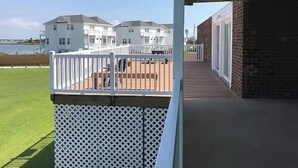 Ein Balkon mit Blick auf einen Strand und weiße Gebäude im Hintergrund.