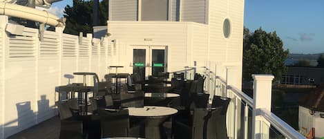 Una terraza en la azotea con asientos exteriores y una pequeña estructura tipo torre.