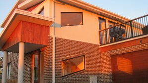 A modern two-story house with a brick facade, a wooden deck, and a garage. - Just 30 seconds walk to DROMANA Swimming BEACH, WIFI, Parking, heating & cooling (Dromana)