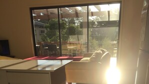 A modern kitchen with a large window, wooden flooring, and a white countertop. - Just 30 seconds walk to DROMANA Swimming BEACH, WIFI, Parking, heating & cooling (Dromana)