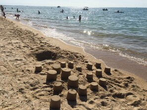 Una playa arenosa con formaciones de arena cilíndricas.