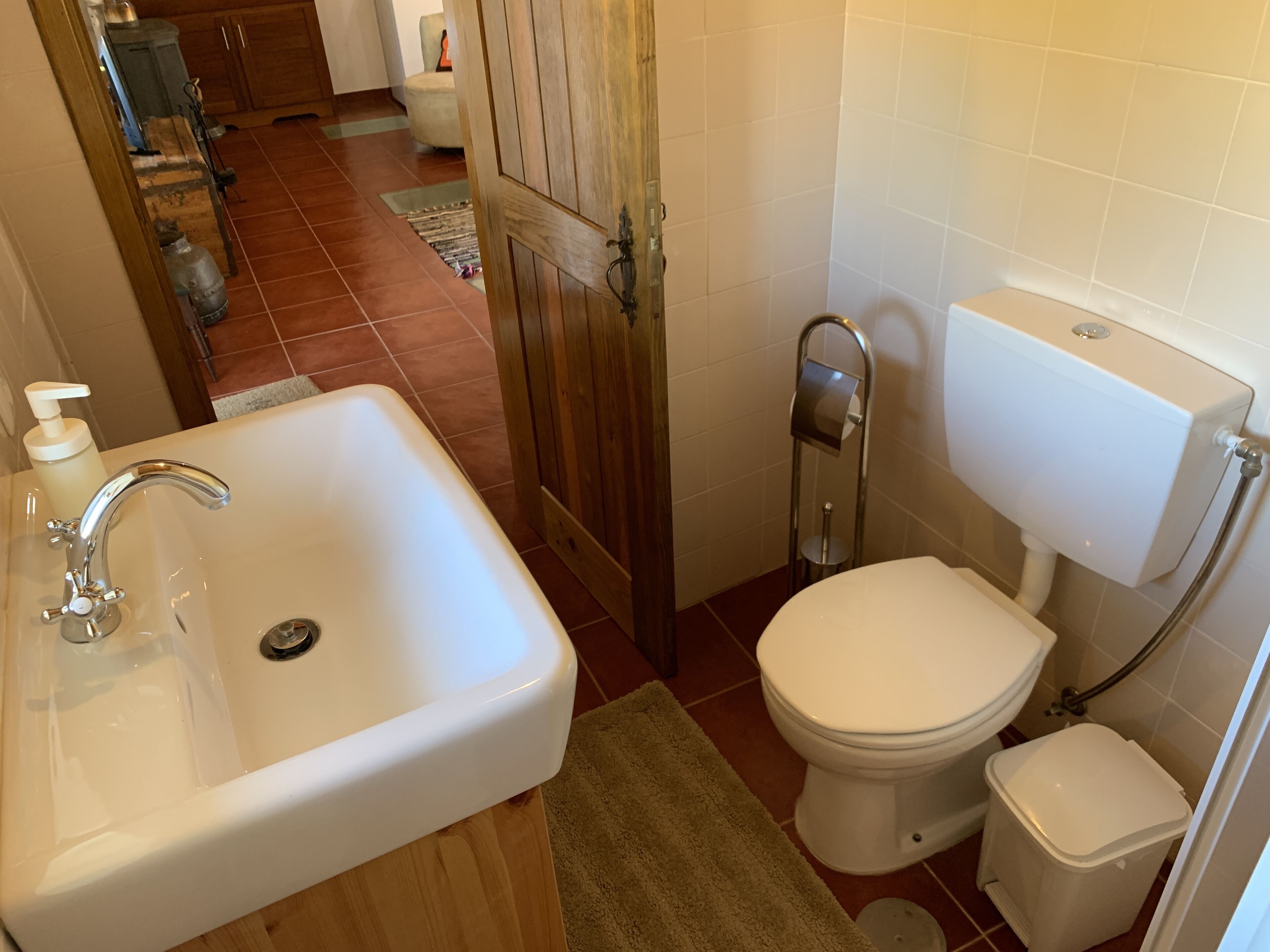 Een kleine badkamer met een witte wastafel, toilet en bidet.