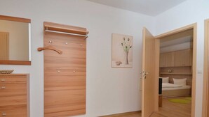 A room with a wooden wardrobe, a mirror, a painting, and a bed. - Vacation apartment Baltic Sea (ground floor) - barrier-free (Sellin)