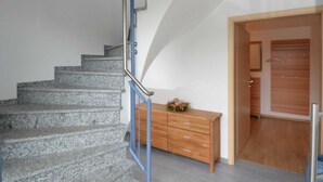 A staircase with a metal handrail leading to a wooden door. - Vacation apartment Baltic Sea (ground floor) - barrier-free (Sellin)