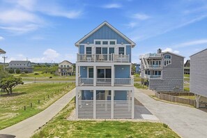 A multi-story building with balconies, a flat roof, and a clear sky.