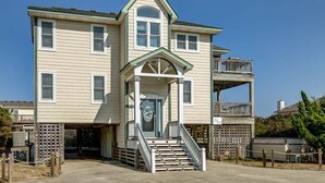 A two-story building with a central entrance, a balcony on the second floor, and a small porch with steps leading up to the entrance. - Summer Place | 325 ft from the beach | Private Pool, Hot Tub | Southern Shores (Southern Shores)