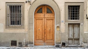Un bâtiment doté d’une grande porte à double battant en bois, de deux fenêtres avec des barreaux en métal et d’une petite fenêtre ornée d’une grille en métal.