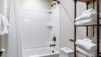 Ein Badezimmer mit Badewanne, Toilette und einem Handtuchregal.