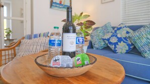 Un bol en bois est posé sur une table, à côté de bouteilles d’eau, d’une bouteille de vin et d’un paquet de chips Pringles.