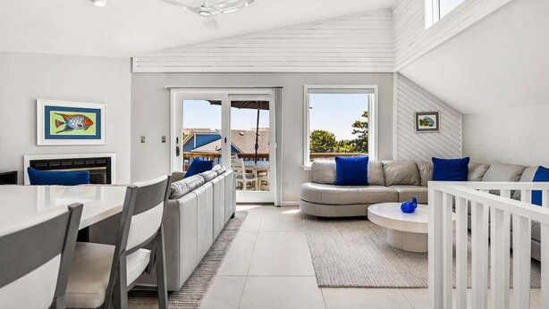 A modern interior with a dining area, sofa, and a view through a glass door. - Easy Livin' | 1040 ft from the beach | Private Pool, Hot Tub | Duck (Duck)