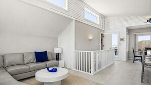 A modern living room with a sofa, coffee table, and a view of the outside. - Easy Livin' | 1040 ft from the beach | Private Pool, Hot Tub | Duck (Duck)