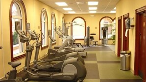 Une salle de sport équipée de tapis de course, de vélos d’appartement et d’appareils de musculation.