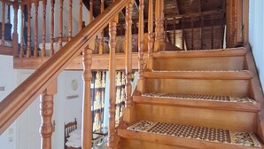 Eine Holztreppe mit gemusterten Teppichläufern und einem Holzgeländer.