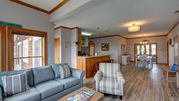 A spacious living area with a sofa, armchair, and dining table.