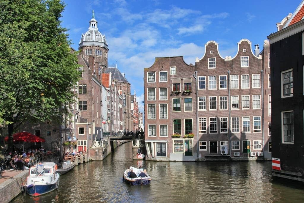 A canal with boats, historic buildings, and a bridge.