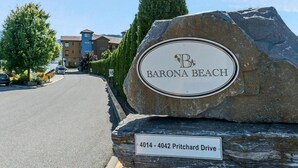 A large rock with a sign for Barona Beach and a street sign for Pritchard Drive. - Barona Beach Lakefront Luxury in front of world class wineries (West Kelowna)