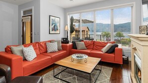 A modern living room with a sectional sofa, a coffee table, and a fireplace. - Barona Beach Lakefront Luxury in front of world class wineries (West Kelowna)