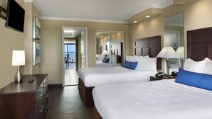 A hotel room with two beds, a desk, a TV, and a bathroom mirror. - Beautiful Oceanfront Suite w/ Great View + Official On-Site Rental Privileges (Myrtle Beach)