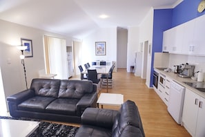 Cozy living area with a sofa and coffee table, leading to a dining space with a table and chairs.