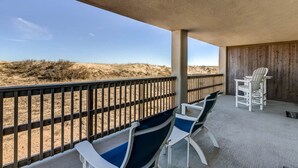 Een overdekt terras met uitzicht op het strand.
