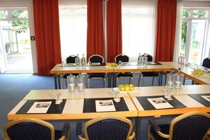 A conference room with tables set for meetings, equipped with water bottles, glasses, and nameplates. - Comfort double room with extra bed - H + Hotel Erfurt (Erfurt)