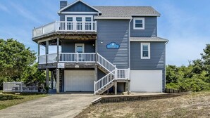 A two-story house with a balcony, a garage, and a sign that reads "Sitting Duck." - A Sitting Duck | 460 ft from the beach | Duck (Duck)