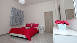 Un dormitorio con cama, mesita de noche y espejo.