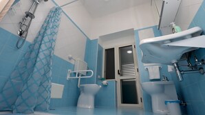 Baño con azulejos azules, ducha, inodoro y lavamanos.