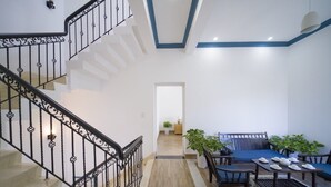 A staircase with ornate black railings, a wooden floor, and a seating area with a sofa and chairs. - hung hoang villa hoi an (Tp. Hội An)